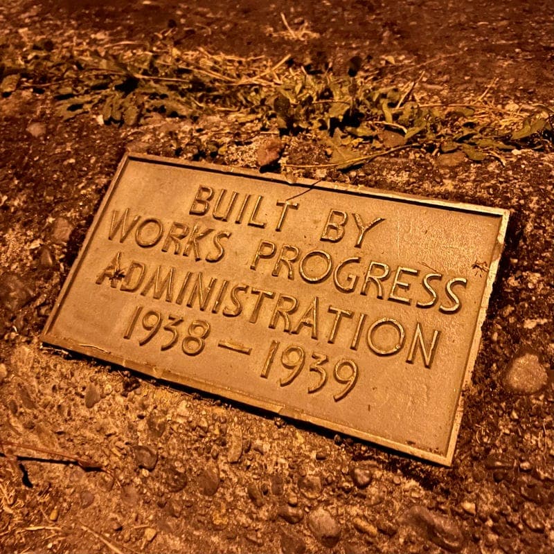 A Built by Works Progress Administration Plaque embedded in the sidewalk in Bremerton's Union Hill neighborhood at night under the glow of the street lights